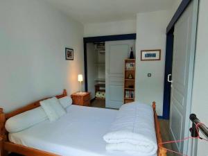 a bedroom with a bed with white sheets at Appartement Cauterets, 2 pièces, 4 personnes - FR-1-234-93 in Cauterets