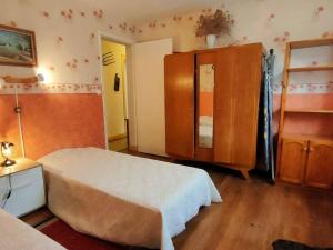 1 dormitorio con 1 cama y armario de madera en Appartement Cauterets, 3 pièces, 6 personnes - FR-1-234-208, en Cauterets
