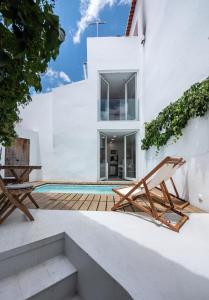 Casa blanca con piscina y 2 sillas en Casa D`Arronches en Arronches