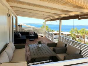 a patio with couches and a table on a balcony at Mobilna kućica Nika in Šimuni