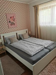 a bed in a bedroom with a polka dot wall at Mediterrán Vendégház in Balatonőszöd