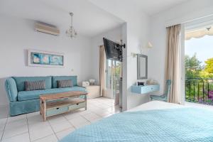 a bedroom with a blue couch and a living room at Arolithos in Spetses