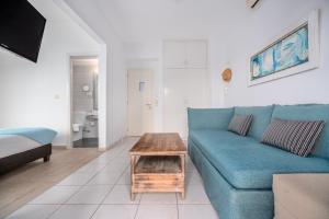 a living room with a blue couch and a coffee table at Arolithos in Spetses
