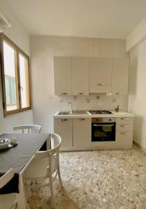 モノーポリにあるCasa Marialuisaのキッチン(白いキャビネット、テーブル、テーブル、椅子付)