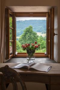 wazon kwiatów siedzący na stole z oknem w obiekcie Zamek Sarny - Schloss Scharfeneck w Kłodzku