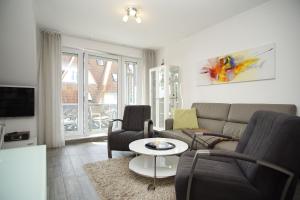 a living room with a couch and a table at gemütliche Ferienwohnung in Hafennähe - FeWos am Hochzeitsberg FeWo 10 in Breege
