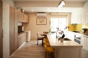 a kitchen with a table and a kitchen with yellow chairs at 微陽二館 in Yilan City