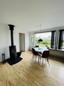 uma sala de estar com uma mesa e um fogão a lenha em aday - Quiet and cozy house em Aalborg