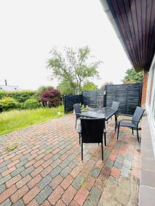 a patio with a table and chairs on a brick patio at aday - Quiet and cozy house in Aalborg