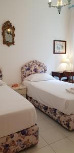 a bedroom with two beds and a chair in it at VILLA NORMA in Levanto