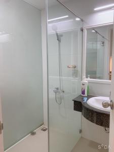 a bathroom with a glass shower and a sink at Comfortable Family Apartment at Sealinks Mui Ne in Ấp Ngọc Hải