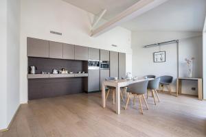 a kitchen and dining room with a table and chairs at La Loge de mer, Lodge urbain in Perpignan