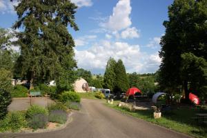 una carretera que conduce a un camping con tiendas de campaña y árboles en Domaine du Heidenkopf, en Niederbronn-les-Bains