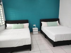 キャメロンハイランドにあるW21 atGoldenHills NightMarket WiFi 4Rのベッド2台が隣同士に設置された部屋です。