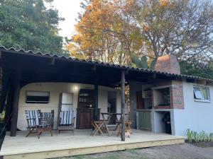 a porch of a house with chairs on it at Milkwoodbend Farm Resort in East London