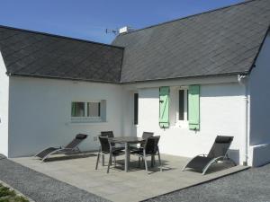 a patio with a table and chairs next to a white building at Les volets verts in Le Crotoy