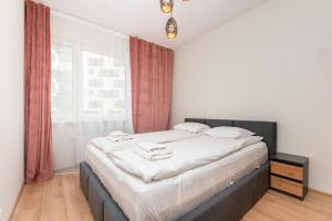 1 dormitorio con 1 cama con sábanas blancas y ventana en Przeworska 9A by Homeprime en Varsovia