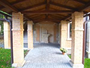 a brick building with a wooden roof and a patio at Pension La Campagna in Hrádek nad Nisou