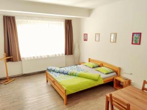 a bedroom with a bed and a table and a window at Apartment Žižkov in Prague