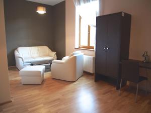 a living room with two chairs and a cabinet at Pension La Campagna in Hrádek nad Nisou