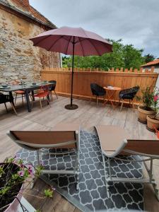 濱海拉普蘭的住宿－Appartement cosy en cœur de bourg，一个带桌椅和遮阳伞的庭院