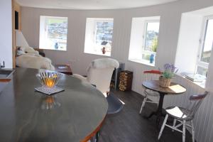 a living room with a table and chairs and windows at Admiral Quarters in Dartmouth
