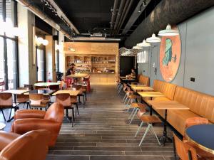 a restaurant with wooden tables and chairs and a classroom at Eklo Hotels Toulouse Cartoucherie Zénith in Toulouse +36 photos