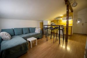 a living room with a blue couch and a kitchen at Apartman Mira in Vir