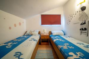 two beds in a small room with a red board at Apartman Mira in Vir