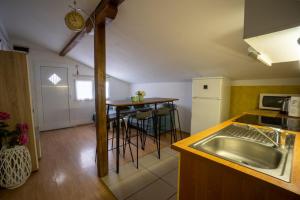 a kitchen with a sink and a table with stools at Apartman Mira in Vir