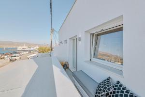 a balcony with a window and a view of the ocean at Nautica Suites - Modern Seaview Suite in Antiparos