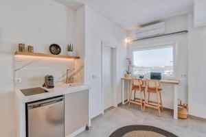 a kitchen with a sink and a counter with a window at Nautica Suites - Modern Seaview Suite in Antiparos