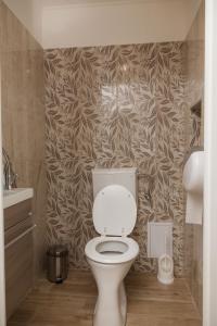 瑙吉伯爾熱尼的住宿－Szívem Csücske Vendégház，一间带卫生间的浴室和一堵带叶子的墙壁