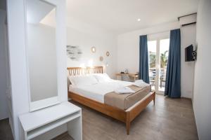 biała sypialnia z łóżkiem i oknem w obiekcie Kaary BellaVita Superior Room w mieście Marzamemi