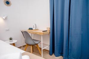 biurko z krzesłem obok niebieskiej kurtyny w obiekcie Kaary BellaVita Superior Room w mieście Marzamemi +22 zdjęcia