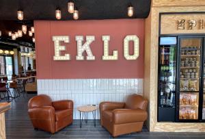 un restaurant avec deux chaises et un panneau indiquant bonjour sur le mur dans l'établissement Eklo Toulouse, à Toulouse