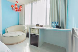 Camera con scrivania, sedia e finestra. di FX Hotel Tainan a Tainan