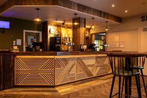 a bar in a restaurant with a wooden wall at Hengar Manor Apartments in Michaelstow