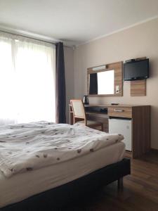 a bedroom with a bed and a desk and a television at Azzurro in Łukęcin