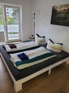 łóżko z poduszkami na górze w pokoju w obiekcie Schöne, gemütliche möblierte 2 Zi Wohnung in RGB w Ratyzbonie