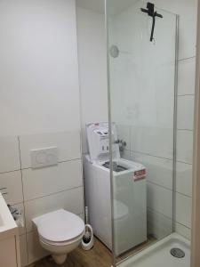 biała łazienka z toaletą i prysznicem w obiekcie Schöne, gemütliche möblierte 2 Zi Wohnung in RGB w Ratyzbonie