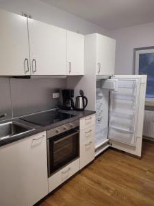 a kitchen with white cabinets and an open refrigerator at Schöne, gemütliche möblierte 2 Zi Wohnung in RGB in Regensburg