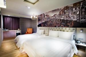 una camera d'albergo con due letti e un dipinto sul muro di FX Hotel Tainan a Tainan
