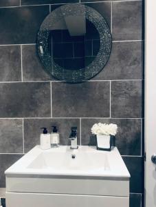 a bathroom with a white sink and a mirror at Chester City Apartments - With free parking in Chester