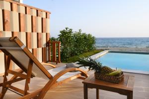 a chair and a basket of fruit next to a swimming pool at Villa Dorra Coast Suites in Kanali