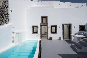 einen Pool in einem Zimmer mit weißen Wänden und Spiegeln in der Unterkunft Alme villas in Vóthon