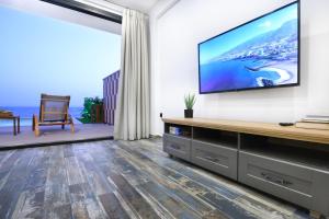 Televízia a/alebo spoločenská miestnosť v ubytovaní Villa Dorra Coast Suites