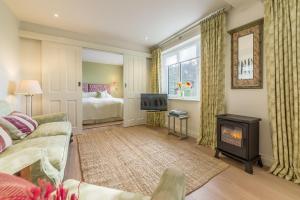 a living room with a fireplace and a bedroom at Marsh View in Aldeburgh