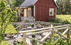 una pequeña casa roja con una valla de madera delante de ella en Amazing Home In Vsterensta With Wifi 