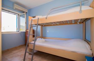 莫奈姆瓦夏的住宿－Laconian Collection ''Le Bleu Infini''，一间卧室设有两张双层床和一扇窗户。